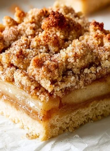 Delicious Apple Crisp Bars with oats and cinnamon on a wooden plate.