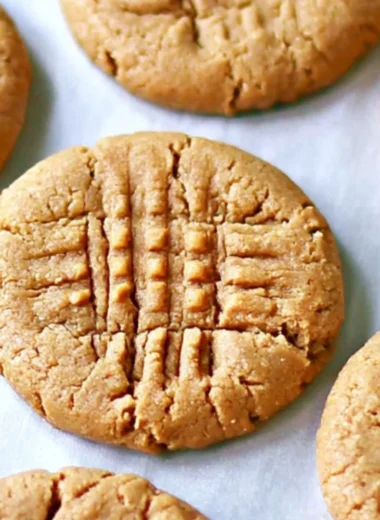 Three delicious homemade peanut butter cookies on a plate.