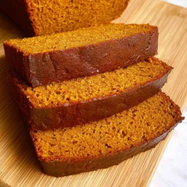 Slices of homemade cozy pumpkin bread on a rustic wooden table