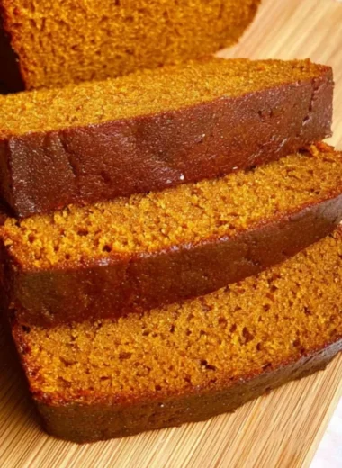 Slices of homemade cozy pumpkin bread on a rustic wooden table