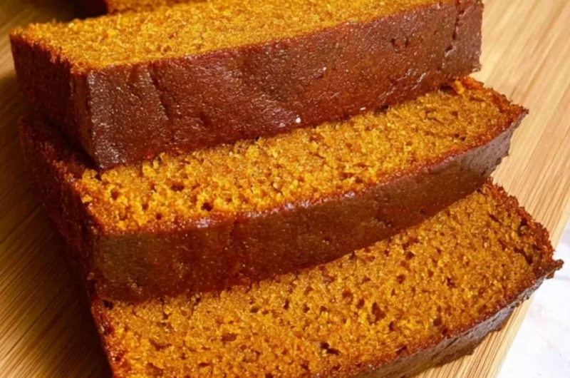 Slices of homemade cozy pumpkin bread on a rustic wooden table