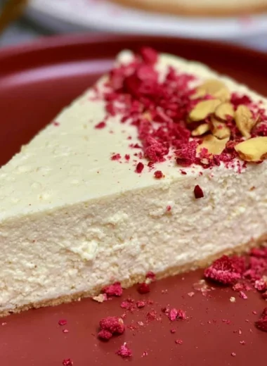 Slice of diabetic cheesecake topped with fresh berries and a light drizzle.