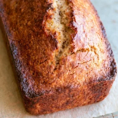 Freshly baked easy banana bread loaf on a wooden cutting board