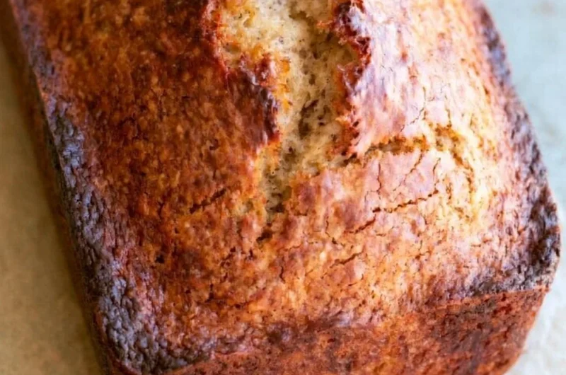 Freshly baked easy banana bread loaf on a wooden cutting board