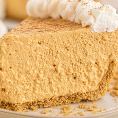 Fluffy Marshmallow Pumpkin Pie topped with whipped cream and spices