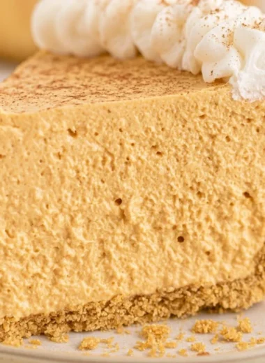 Fluffy Marshmallow Pumpkin Pie topped with whipped cream and spices