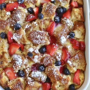 Delicious French Toast Casserole served with syrup and berries