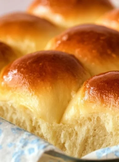 Freshly baked Grandma's buttery dinner rolls stacked on a plate