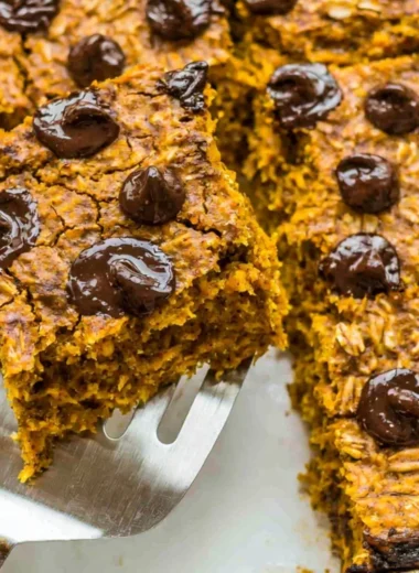 Bowl of pumpkin baked oatmeal with chocolate chips topped with nuts