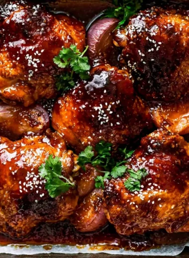 Baked Sticky Honey Soy Chicken garnished with sesame seeds and green onions