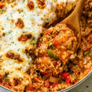 Colorful stuffed pepper casserole topped with cheese and herbs
