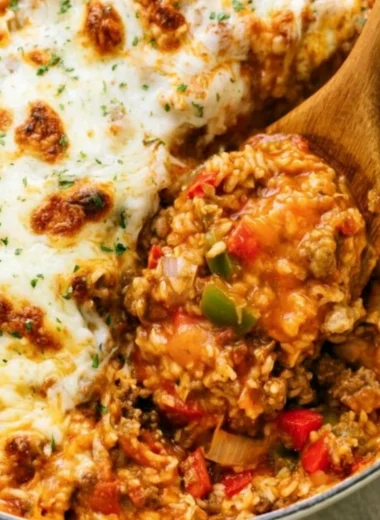Colorful stuffed pepper casserole topped with cheese and herbs