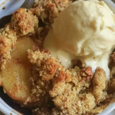 Delicious sugar free apple crisp dessert served in a bowl with a scoop of ice cream.