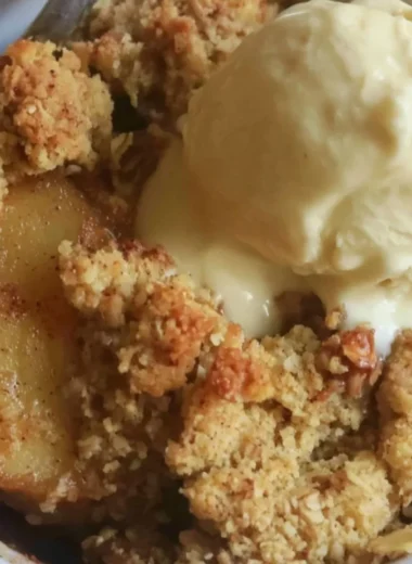 Delicious sugar free apple crisp dessert served in a bowl with a scoop of ice cream.