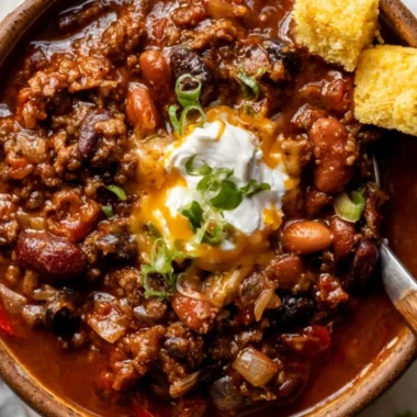 Delicious bowl of cozy chili recipe topped with cheese and green onions