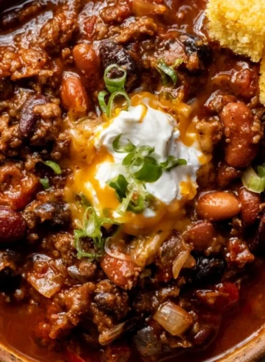 Delicious bowl of cozy chili recipe topped with cheese and green onions