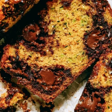 Loaf of cozy chocolate chip zucchini bread garnished with chocolate chips.