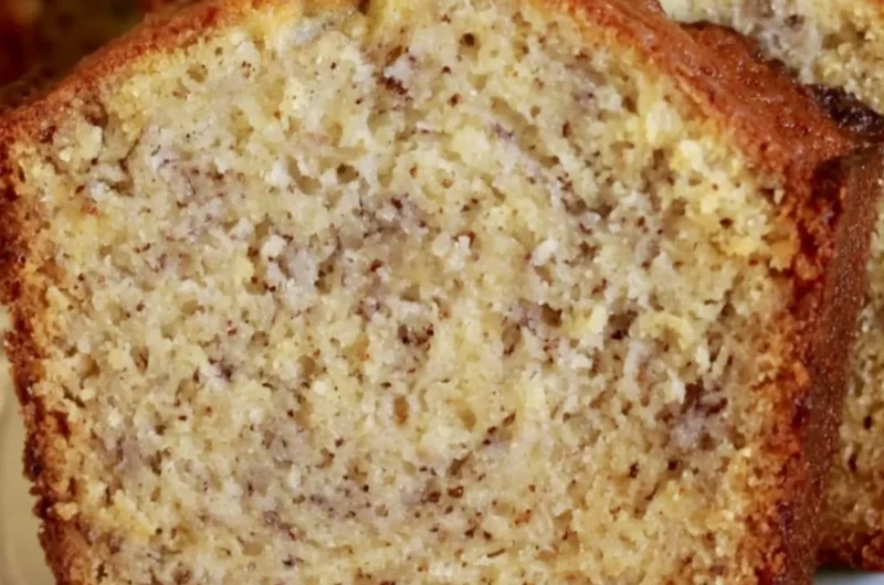 Loaf of cozy perfect banana bread on a wooden table with fresh bananas