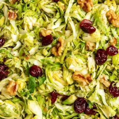 Cozy shaved Brussels sprouts salad with colorful toppings and dressing.