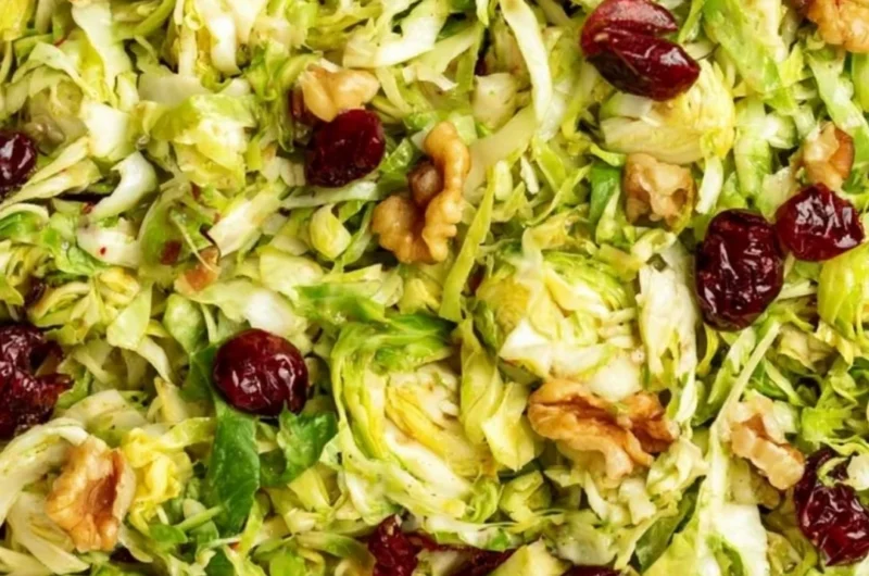 Cozy shaved Brussels sprouts salad with colorful toppings and dressing.