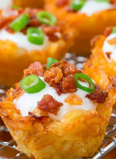 Plate of loaded tater tots topped with cheese, bacon, and green onions