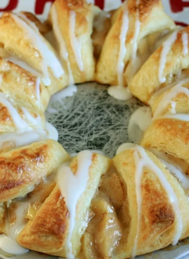 Cozy apple crescent ring served on a rustic plate with autumn leaves.