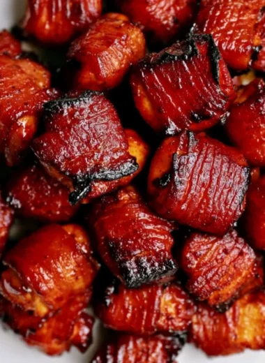 Bacon Chicken Bites served on a white plate garnished with herbs