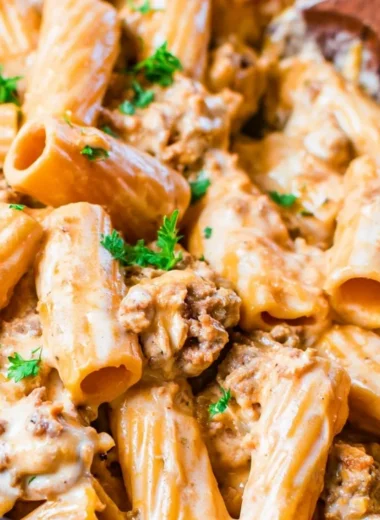 A creamy bowl of cozy homemade cheeseburger pasta topped with cheese and herbs