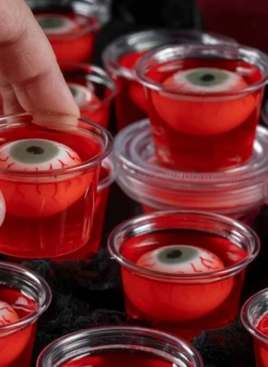 Creepy eyeball jello shots served in cocktail glasses for Halloween party decoration.