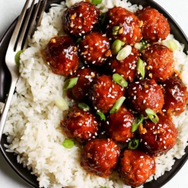 Plate of honey garlic meatballs garnished with green onions and sesame seeds