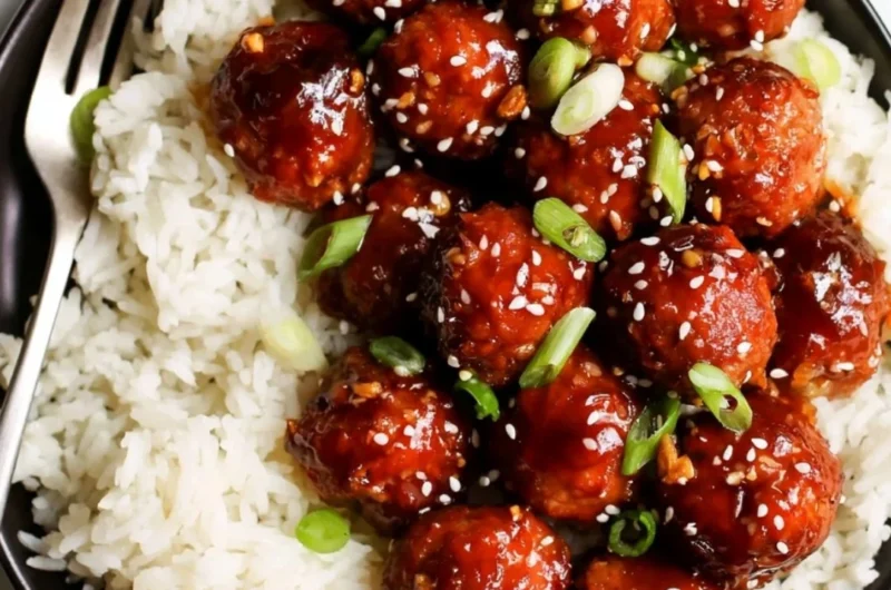 Plate of honey garlic meatballs garnished with green onions and sesame seeds